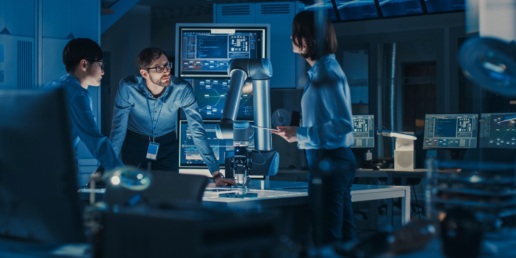 A diverse team of engineers meeting in a laboratory discussing a robotic project.